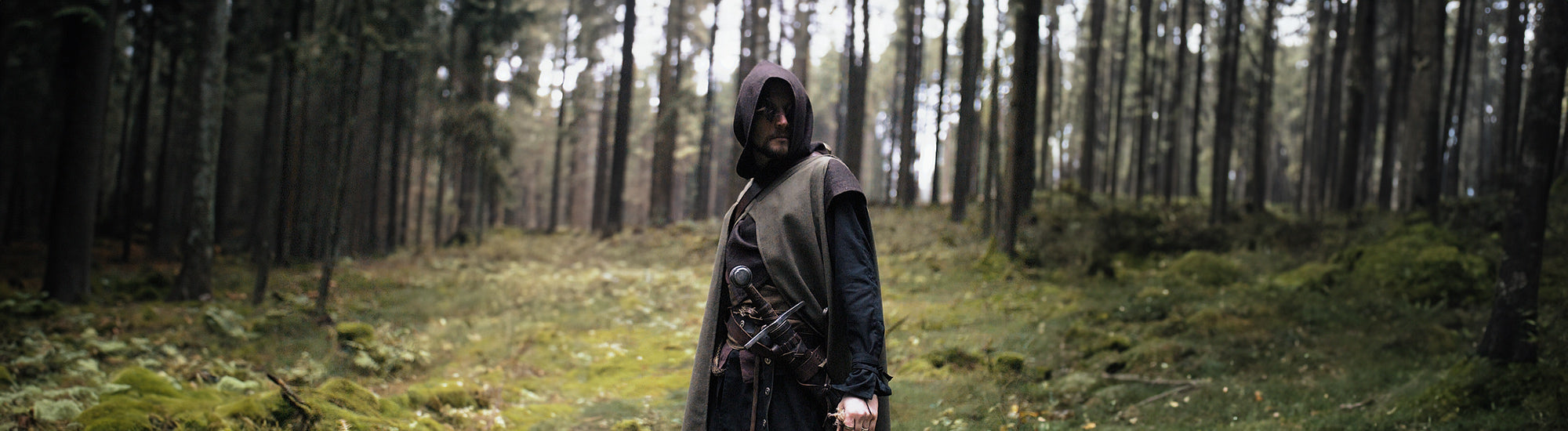 Lone ranger his clothing is in natures colours. A green cape that also covers his front, a brown vest with a hood and black shirt.