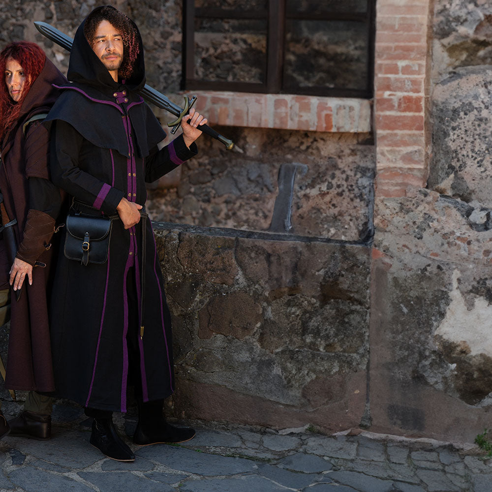 D&D warlock, dressed in black and purple garments from Burgschneider. He is waiting with the ranger for the rest of the party to gear up.